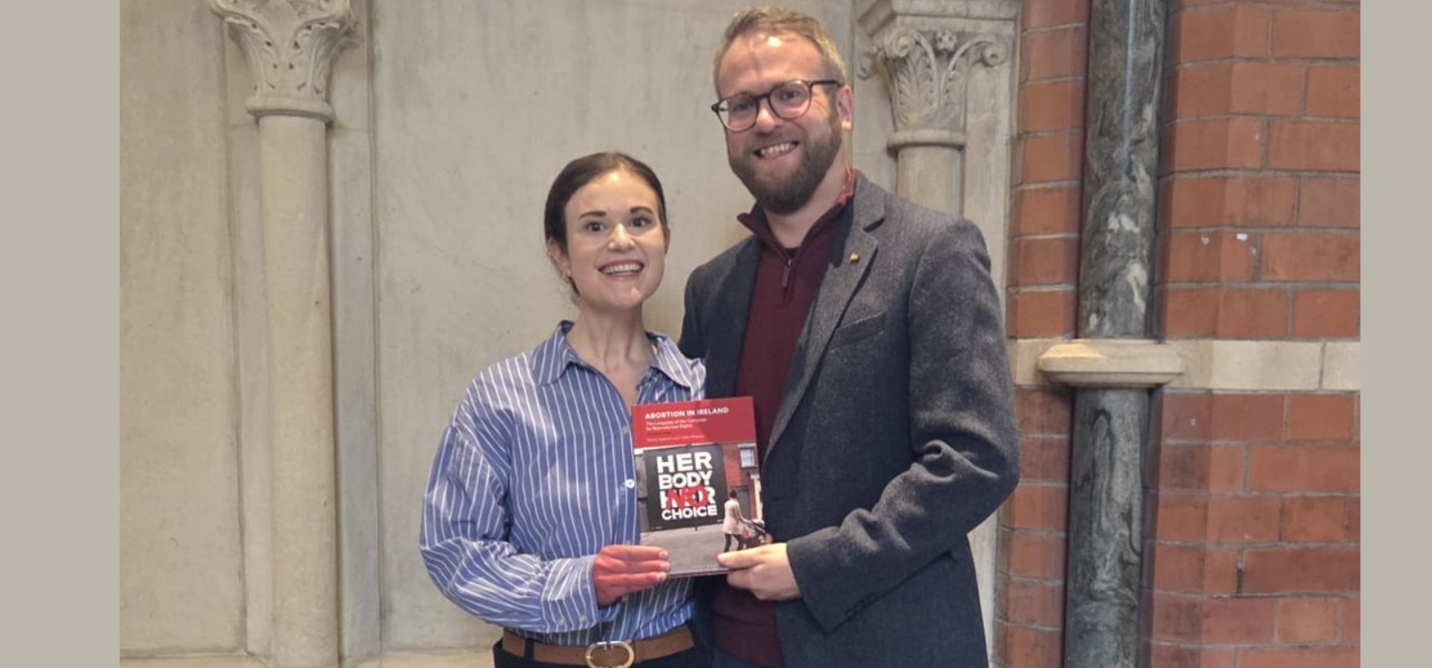 two people holding a book for a book launch event